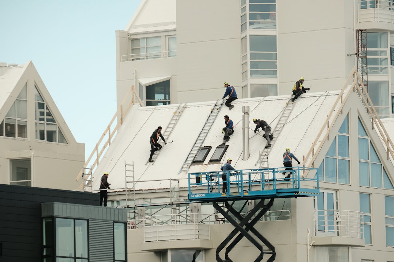 Construction workers repairing a modern roof in Reykjavík, highlighting teamwork and safety.